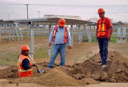 Imagen de tres hombres excavando con palo dentro de la granja de energia solar en La Paz.
